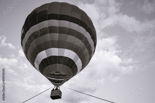 Balloon Festival Montgolfier, close-up of a striped hot air balloon in the air against a cloudy sky during tethered flight, monochrome photo, vintage, wallpapers, photography has copy space