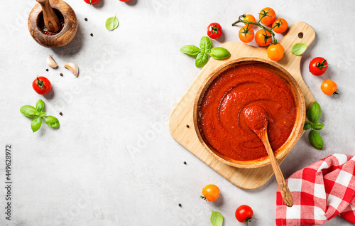 Classic homemade Italian tomato sauce with basil for pasta and pizza. Light gray stone background. top view