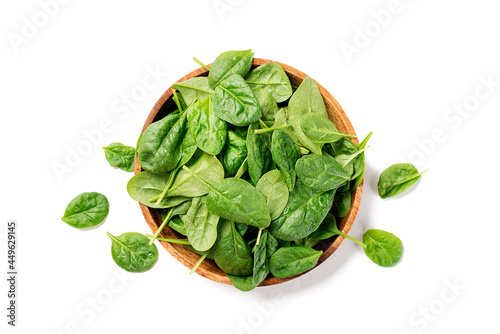 Fresh spinach leaves on wooden plate. Healthy vegan food. Top view. isolated on white background.