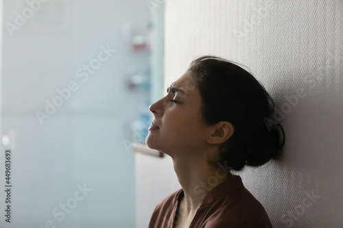 Close up of unhappy young Indian woman feel depressed suffer from loneliness solitude at home. Upset sad millennial mixed race female loner struggle with depression after abortion or miscarriage.