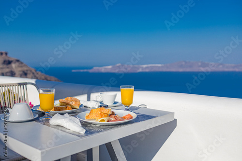 Morning fresh juice and breakfast with blue sea view. Couple traveling and honeymoon destination, idyllic morning scenic, bright caldera view in Greece, Santorini island. Romantic landscape, happiness