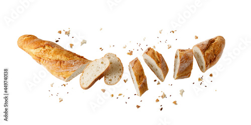 Cutting fresh baked loaf wheat baguette bread with crumbs and seeds flying isolated on white