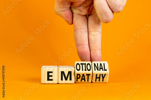 Emotional empathy symbol. Doctor turns wooden cubes and changes the word 'Emotional' to 'Empathy'. Beautiful orange table, orange background, copy space. Psychology, emotional empathy concept.