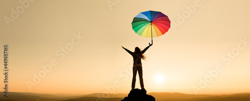 Frau mit einem Schirm auf einem Berggipfel