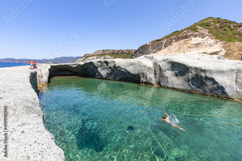 Cane Malu, a man swims in the beautiful natural pool carved into the rock on the west coast of Sardinia, Bosa, Oristano, Italy, Europe