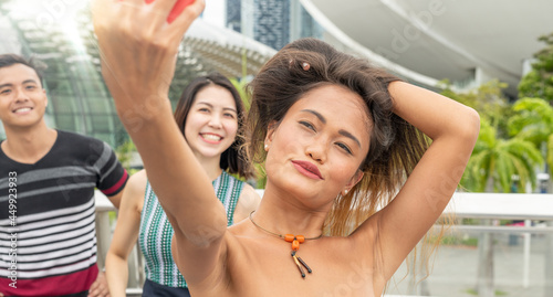 Three asian young friends take selfies as tourists
