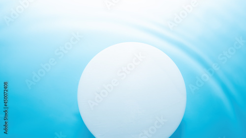 Empty white circle podium on water with waves in sunlight. layout, copyspace.Abstract background for product presentation.