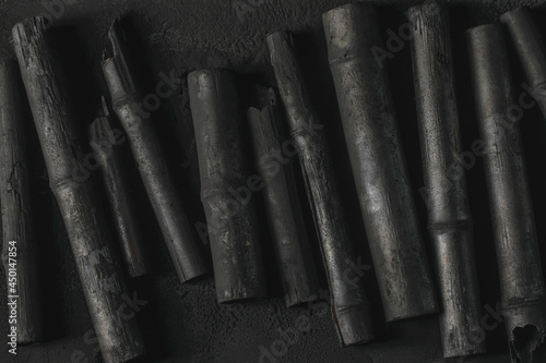 Bamboo charcoal stick on coal powder black background..Powerful water purifier