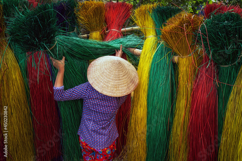 Back side of Vietnamese female craftsman drying traditional vietnam mats in the old traditional village at dinh yen, dong thap, vietnam, tradition artist concept