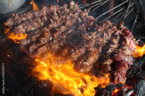 sate kambing or satay goat, lamb, Lamb or meat goat satay with charcoal ingredient on red fire grilling by people. traditional satay from yogyakarta, java, Indonesiacooking satay