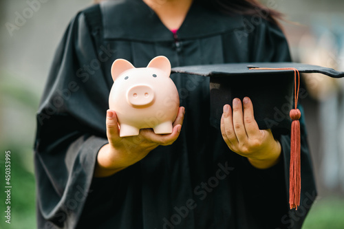 graduates holding piggy banks saving concept