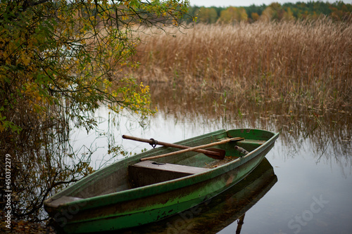 Łódź rybacka na brzegu jeziora czeka na nadejście wiosny. Jesień. Koniec sezonu.