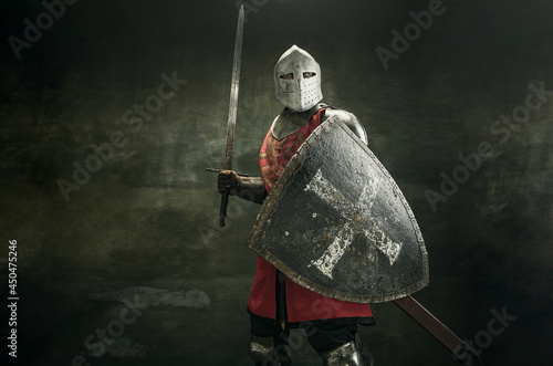 One medeival warrior or knight in armor and helmet with shield and sword