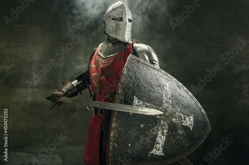 One medeival warrior or knight in armor and helmet with shield and sword