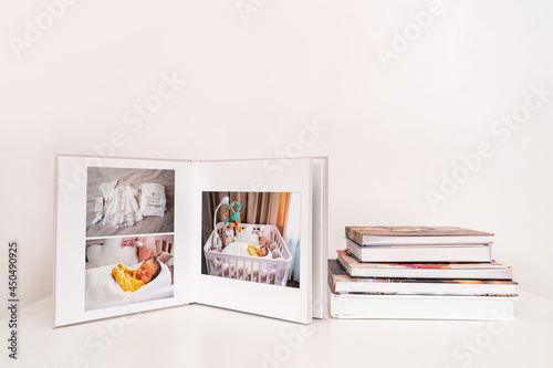 on white table open photobook from photo shoot of family with newborn.