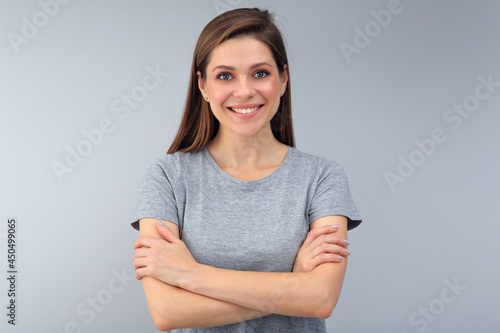 Smiling young woman standing with crossed arms.
