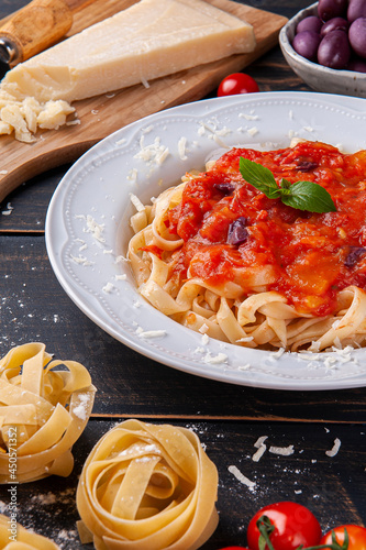 .Italian pasta dish with tomato sauce. Composition with ingredients for the preparation of the dish.