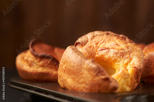 Fresh cooked yorkshire puddings on a wooden background.