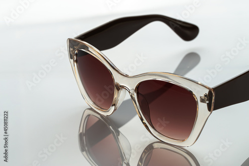 Sunglasses on a white reflective surface. Fashionable, stylish accessories. Use it for a vacation or summer concept.