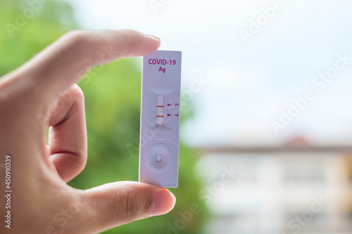 man holding Rapid Antigen Test kit with Positive result during swab COVID-19 testing. Coronavirus Self nasal or Home test, Lockdown and Home Isolation concept