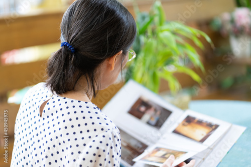 senior asian woman looking at photo album to remind of old happy memmory