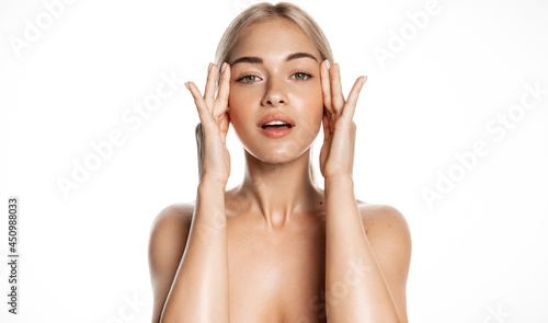 Spa and skin care. Young female model with healthy, glowing face and body, massaging using facial lotion, anti-aging cream or serum, rubbing cosmetic product with fingers, white background