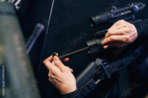 Professional female sniper hands assembling a gun