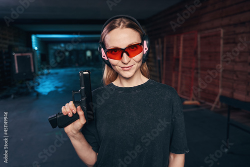 Confident female shooter in safety goggles looking ahead