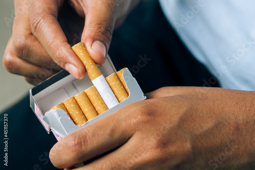 Cigarette.World No Tobacco Day Concept.closeup woman hand holding peel it off cigarette pack prepare smoking a cigarette.