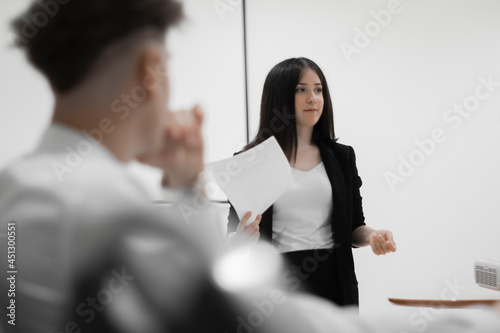 Chica joven en una conferencia de trabajo explicando informes de trabajo