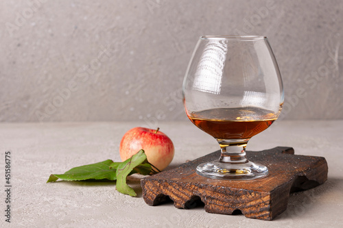 calvados in a wine glass on a wooden board space for text