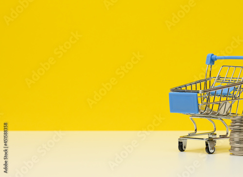 metal trolley and small change on a white table. Savings concept, discounts, low purchasing power
