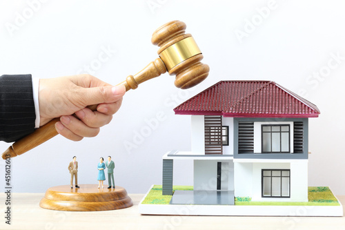 Property auction, Woman hand holding gavel wooden and model house on white background, lawyer of home real estate and ownership property concept