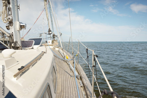 Herreshoff designed old classic yacht sailing in an open sea. Wooden teak deck. View to the mast and sails. Ketch sailboat. North American boat building traditions. Cruise, vacations, regatta, sport