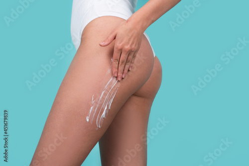Cosmetic cream on woman buttocks with clean soft skin. Applying moisturizer cream on butt. Cellulite or anti cellulite treatment. Body care and spa salon concept. Slim fit woman body.