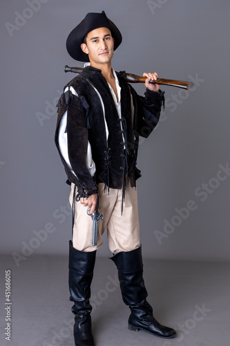 A pirate man wearing a black leather jerkin and holding a gun