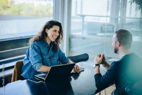 Smiling businesswoman taking interview of a job applicant.