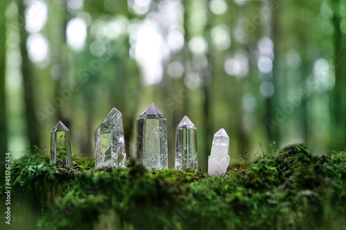 Clear crystals in mysterious forest, natural green background. Magic quartz minerals for healing Crystal Ritual, Witchcraft, spiritual esoteric practice. Reiki life balance concept