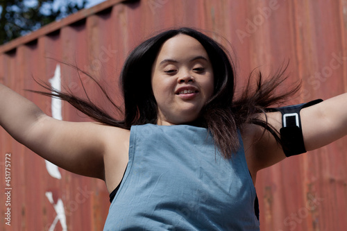 Young biracial woman with Down Syndrome in active wear and wearable tech working out