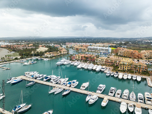 Unique aerial view of exclusive Sotogrande Bay - Costa del Sol. Cloudy day and rainy , beautiful sky colours. Luxury real estate and yacht. Famous location. 