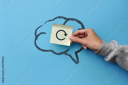 A silhouette of the brain and a sticker with the image of the reboot icon. A symbol of a break in the work of thinking