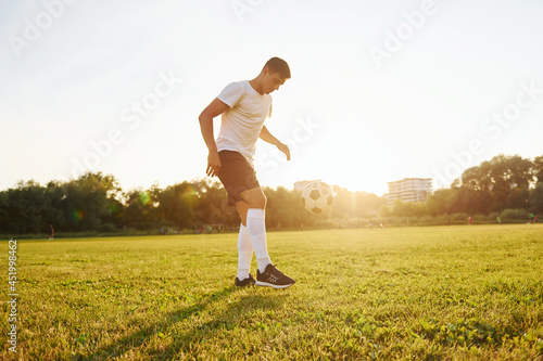 Forest on background. Young soccer player have training on the sportive field