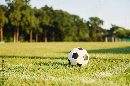Close up view of soccer ball that lying down on the green grass