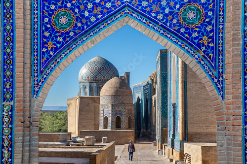 View over the mausoleums and domes of the historical cemetery of Shahi Zinda through an arched gate, Samarkand, Uzbekistan