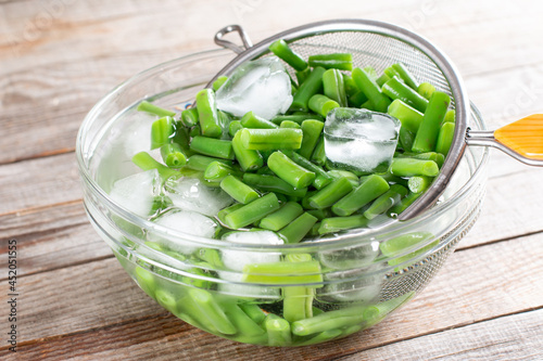 Green beans in a colander. Boiled or blanched vegetables on a table