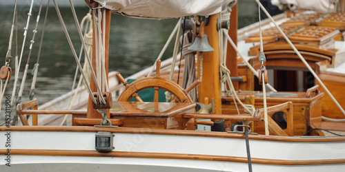 Expensive retro sailing boat (ketch) moored to a pier in a new yacht marina. Wooden teak deck, elegant details. Transportation, nautical vessel, vacations, tourism, cruising, regatta, recreation