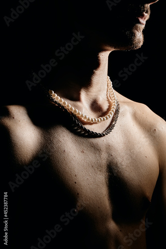 jeune homme homosexuel torse nu portant des bijoux