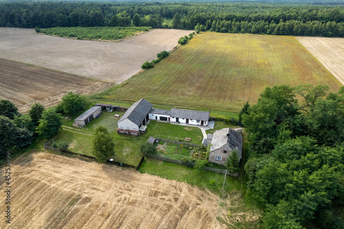 Wiejska osada, zabudowania wiejskie, podczas lata, pole, łąka z lotu ptaka, dron