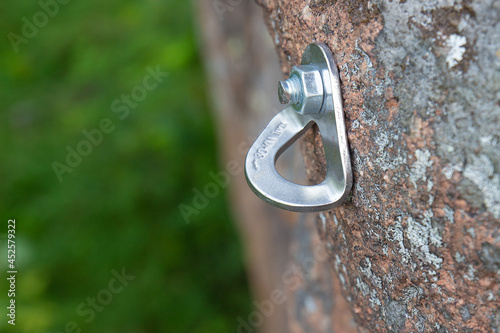 Close-up of reusable rock climbing bolt on rock face. Climbing equipment designed to organize belay points on the rocks.
