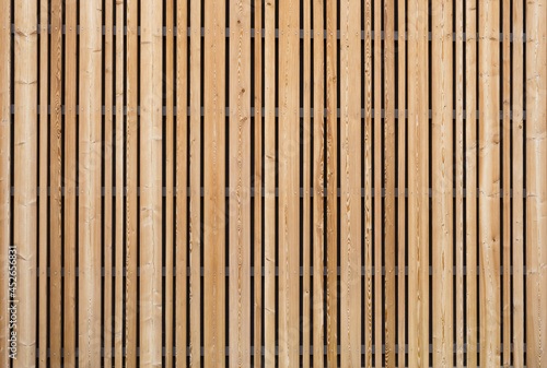 Background modern facade or ceiling made of larch wood strips in the outdoor